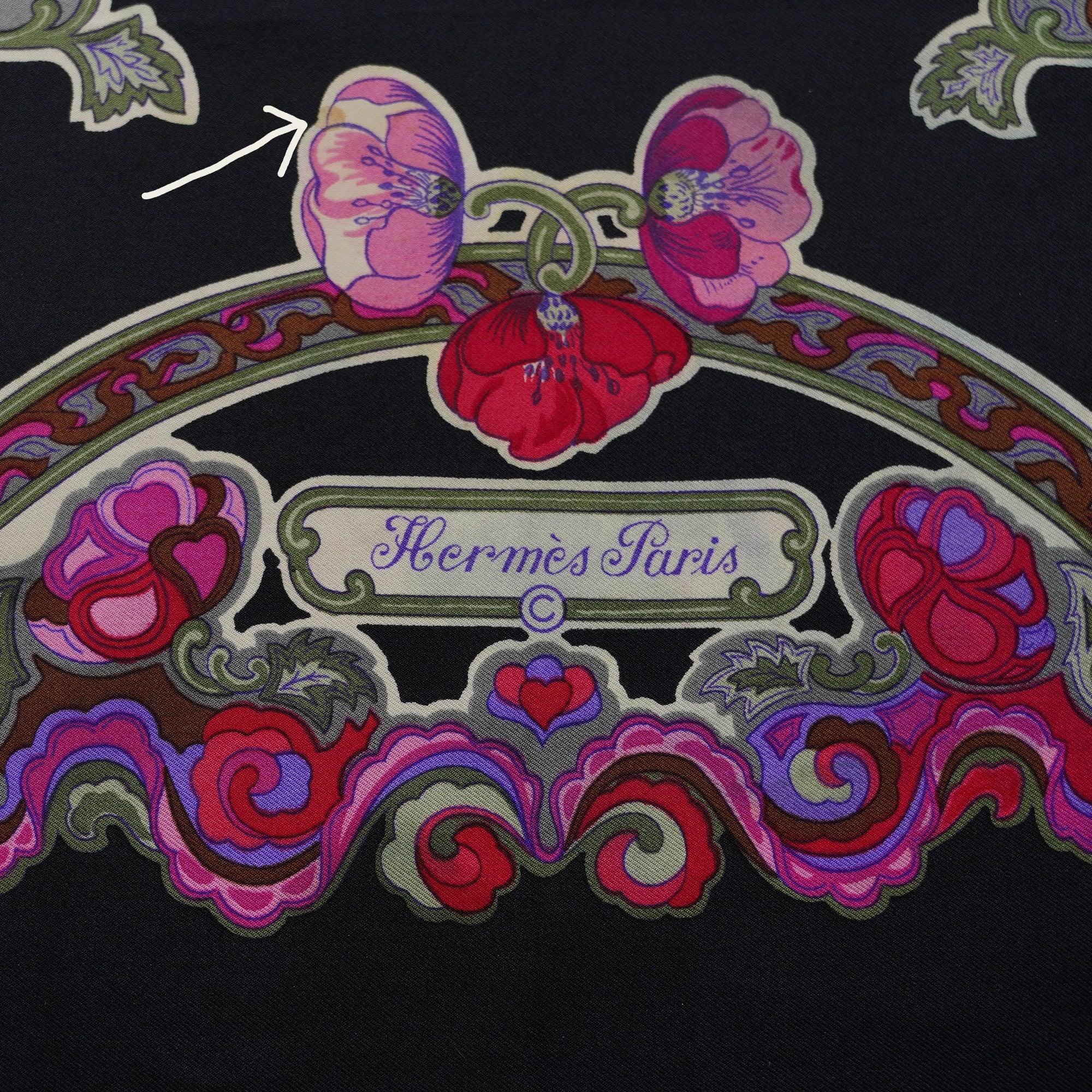 Détail de la soie sur le foulard vintage Hermès, une flèche indique une petite tâche