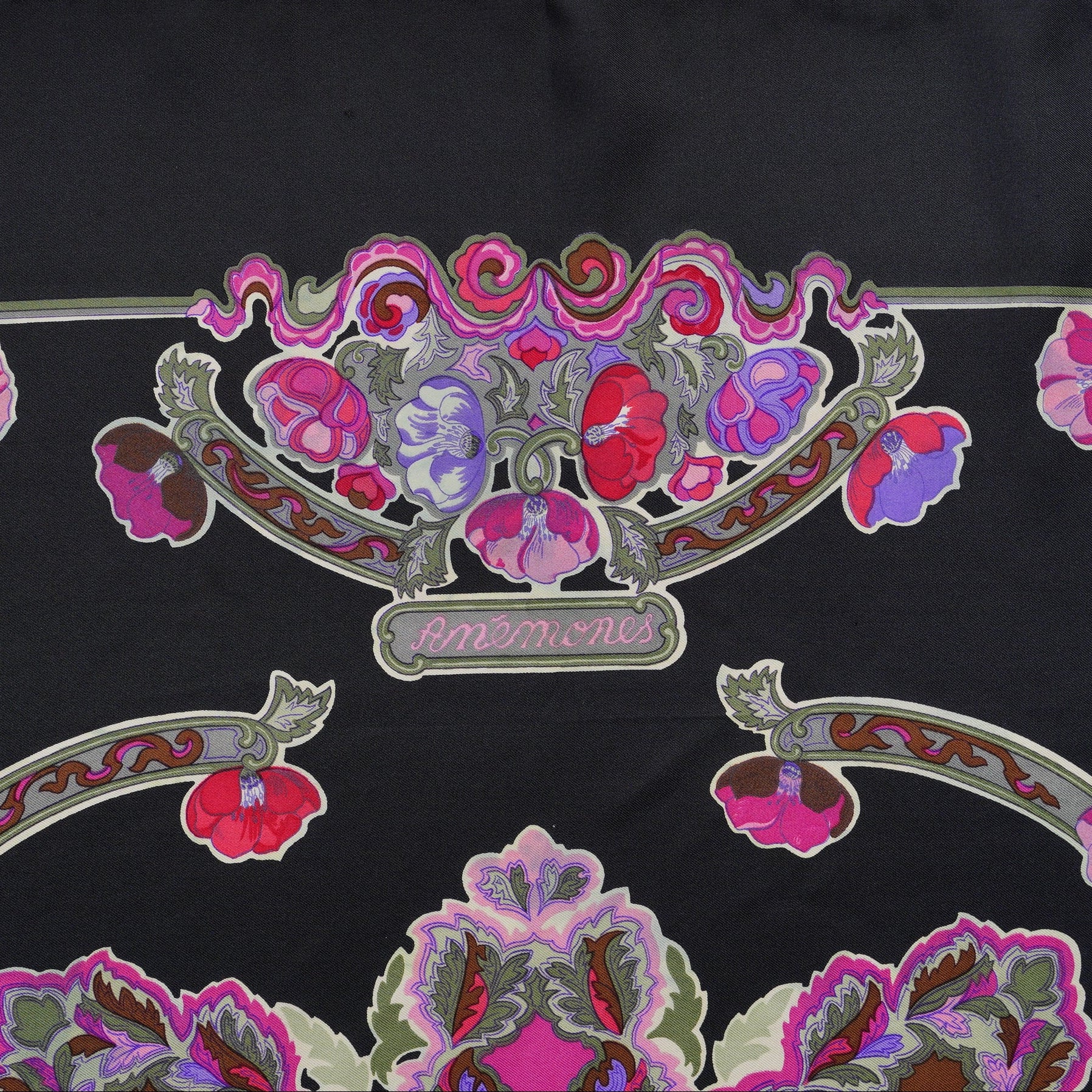 Mise en valeur des motifs artistiques et du roulotté noir ton sur ton du carré de soie Hermès "Anémones" 1980.