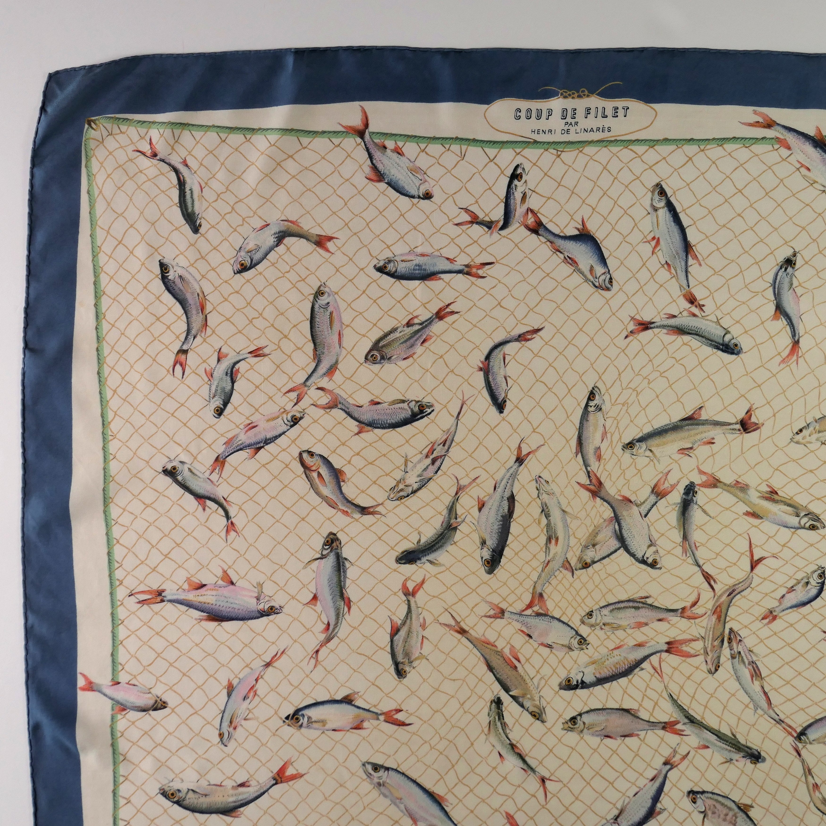 Carré Hermès Coup de Filet 90 cm soie, détail bordure bleu pétrole et filet maillé