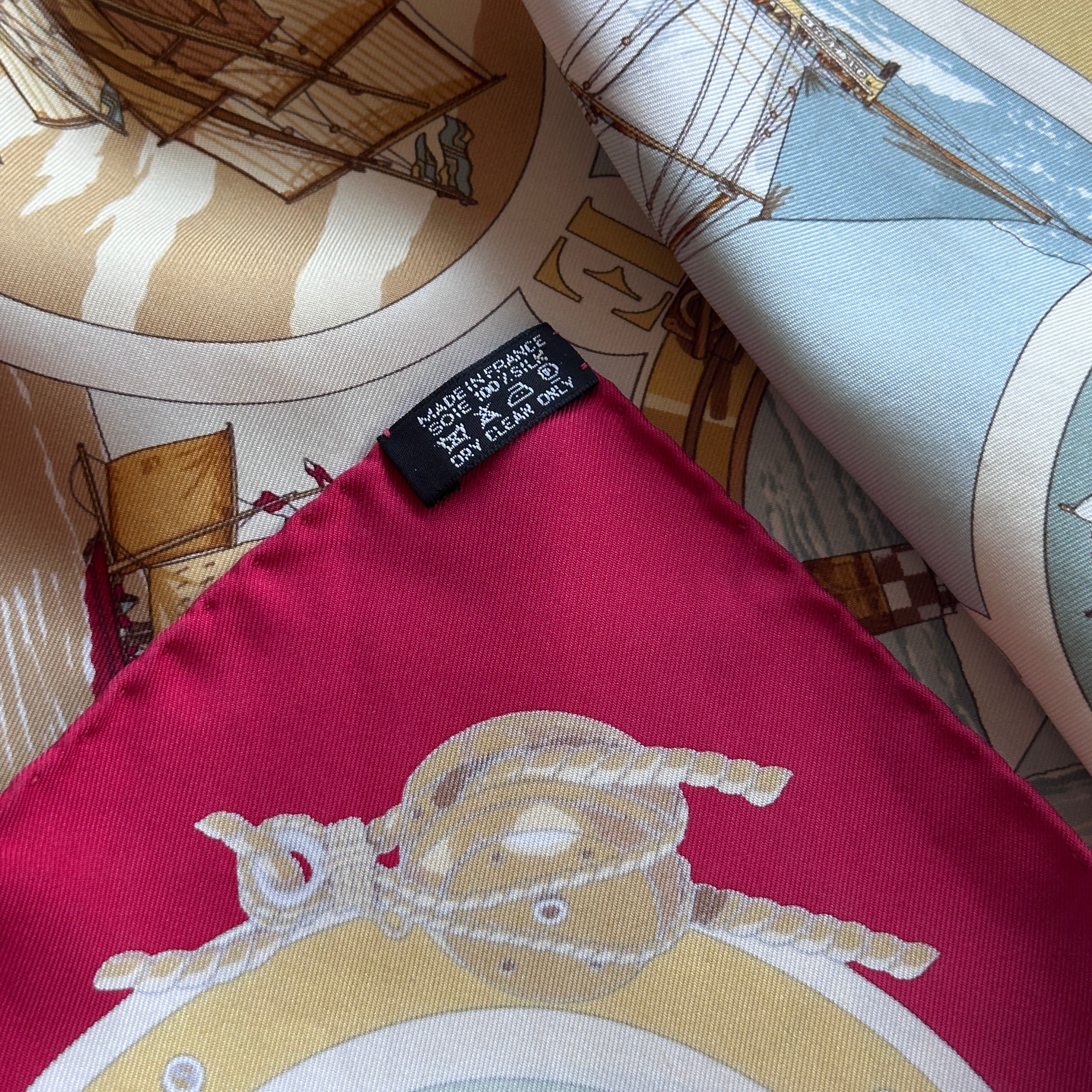 Vue de l'étiquette d'entretien noire cousue sur le bord roulotté rouge.